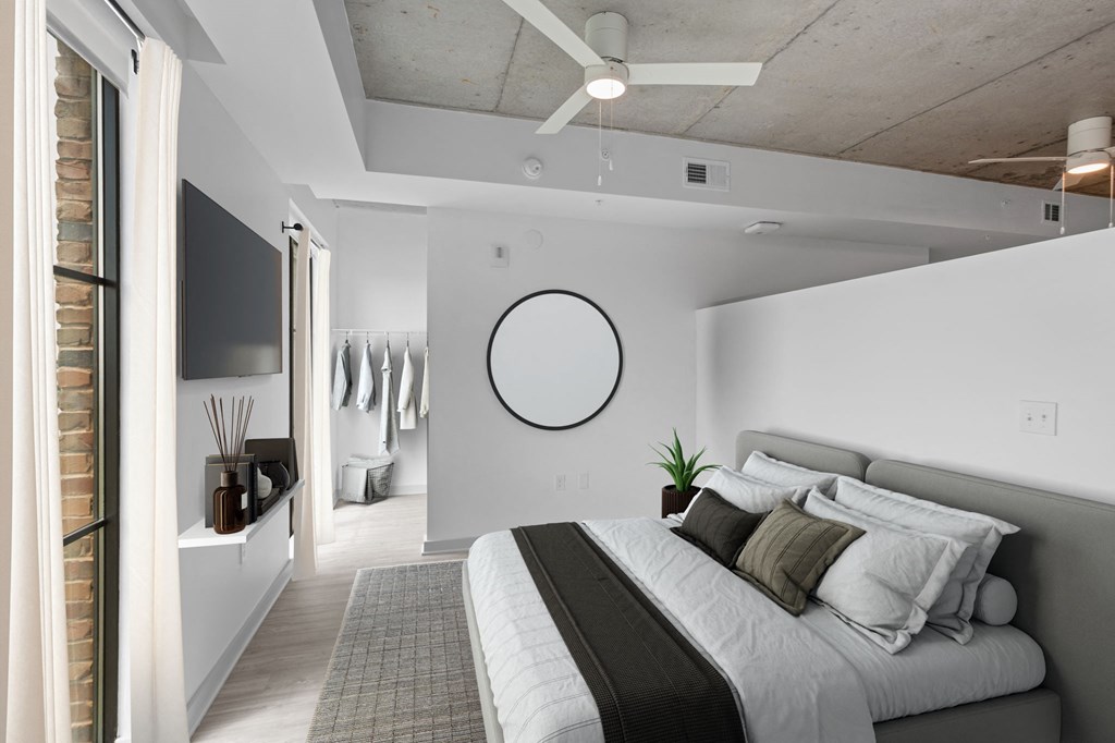 a bedroom with a bed and a ceiling fan