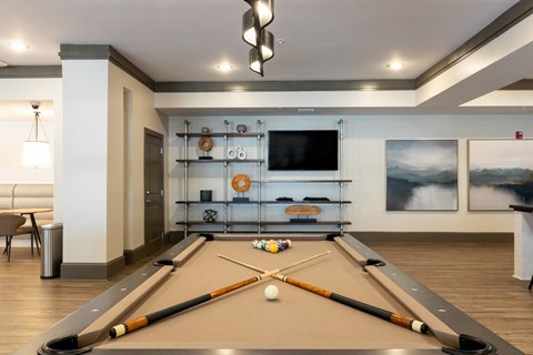 A pool table with a white ball and two cues on it.