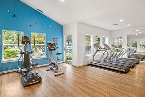 Gym with cardio machines and windows at the district flats apartments at Canyon Creek, Wilsonville