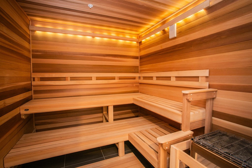 a sauna with wooden benches and a chair