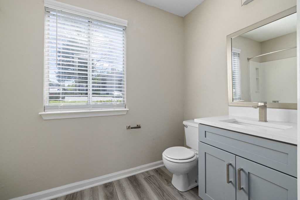 an empty bathroom with a toilet and a window