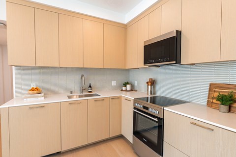 A kitchen with a black microwave above the stove.