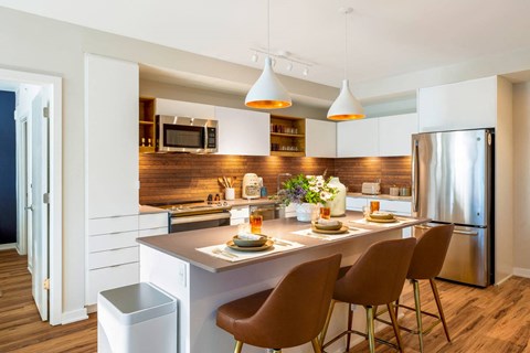 a kitchen with a center island and a stainless steel refrigerator