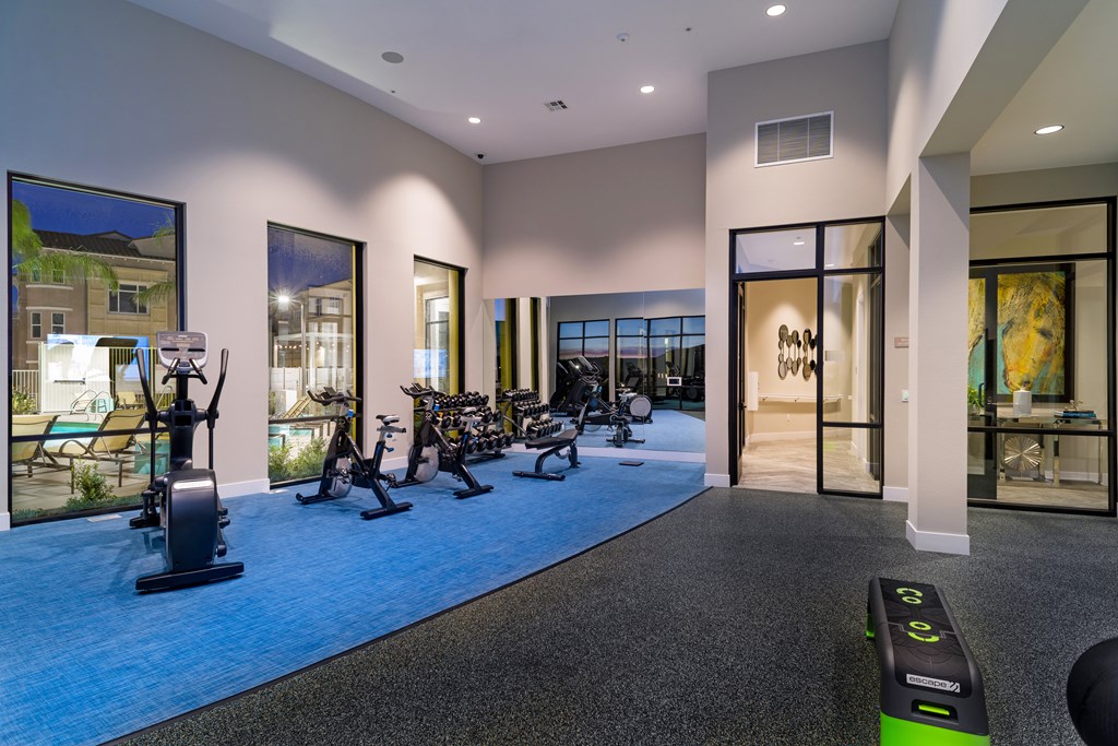 A gym with a row of exercise bikes and a row of exercise machines.