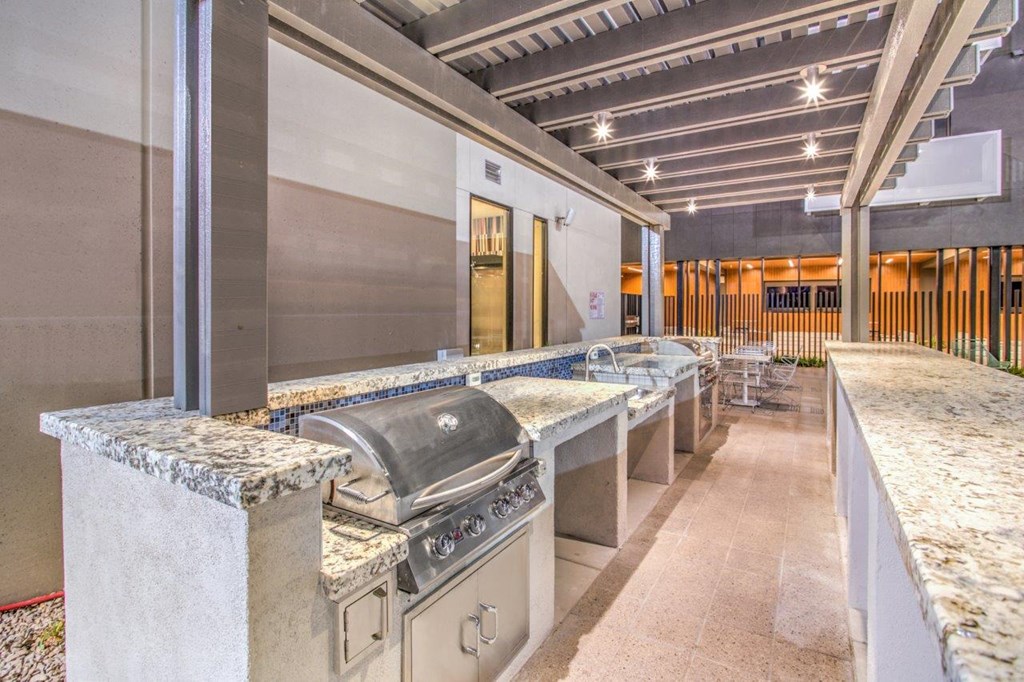 an outdoor kitchen with stainless steel appliances and granite counter tops