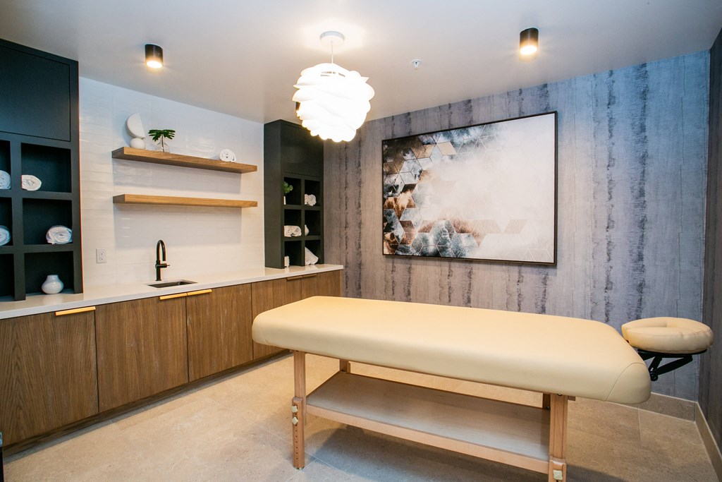 a spa room with a massage table and a large painting on the wall