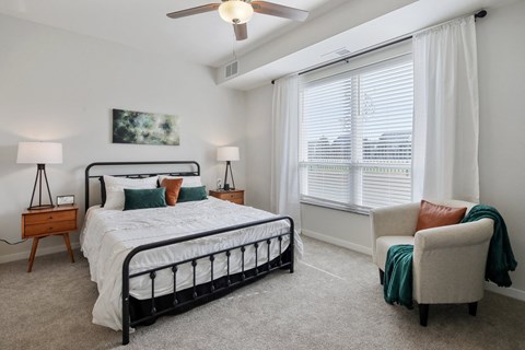a bedroom with a bed and a window and a ceiling fan
