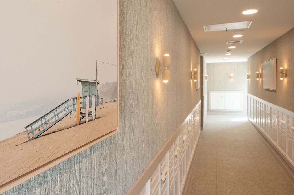 a hallway with a view of the beach and a railing with lights