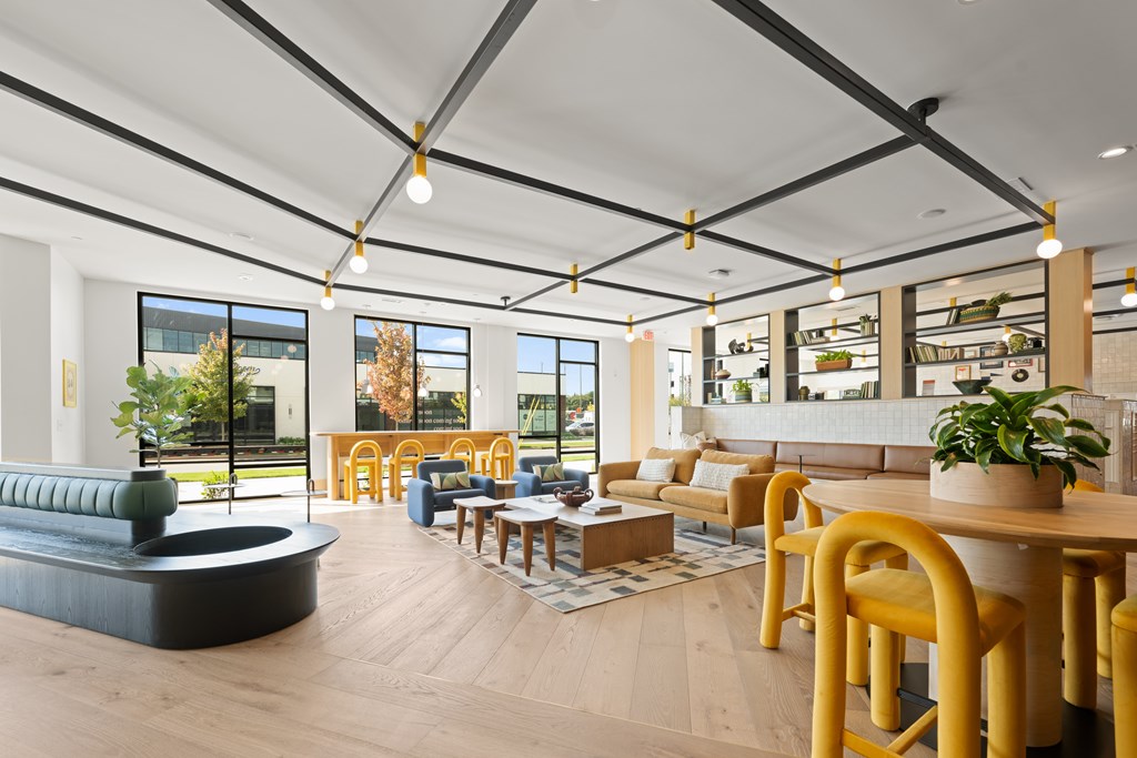 A modern living room with a black sofa and yellow chairs.