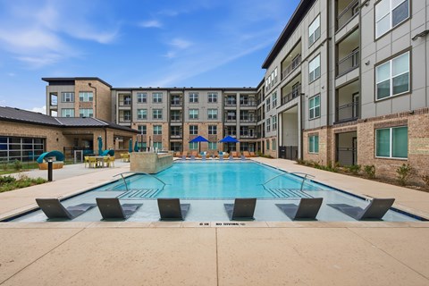 A swimming pool in front of apartment buildings.
