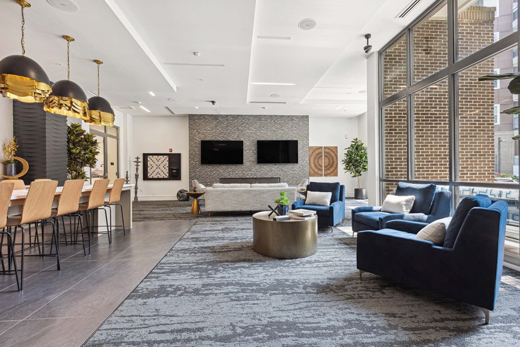 a living room with blue couches and chairs and a large window