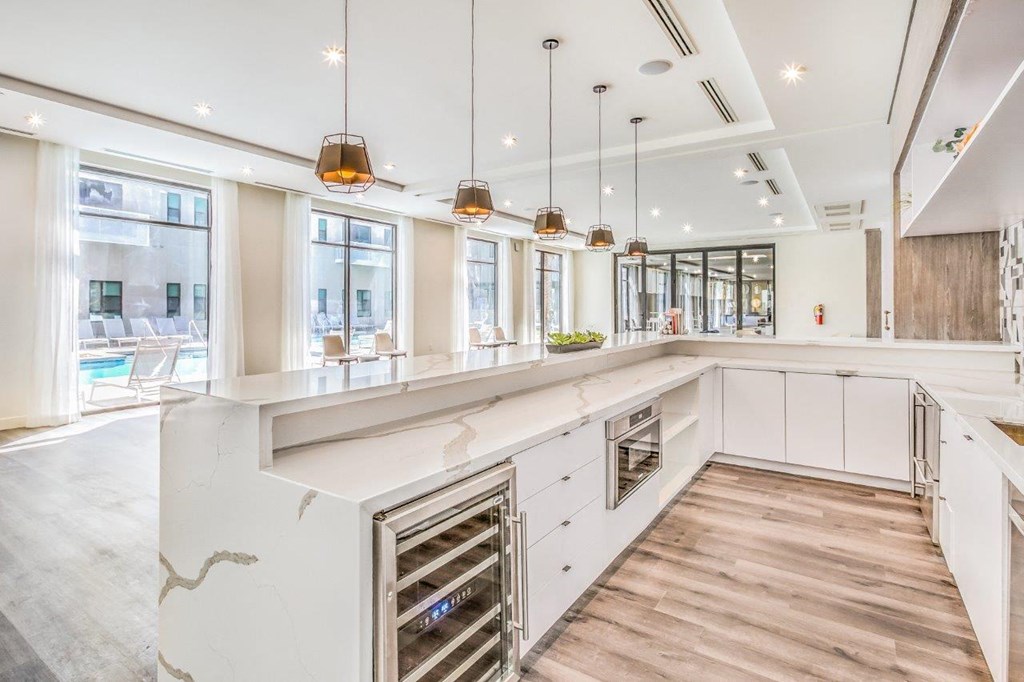 a large white kitchen with a large island in the resident lounge