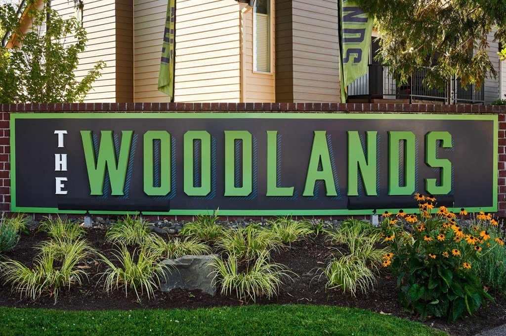 a sign in front of a house that says the woodlands