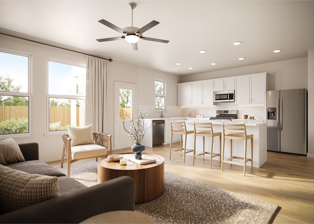 A modern living room with a kitchen in the background.