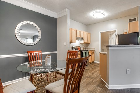 A kitchen with a dining table and chairs.