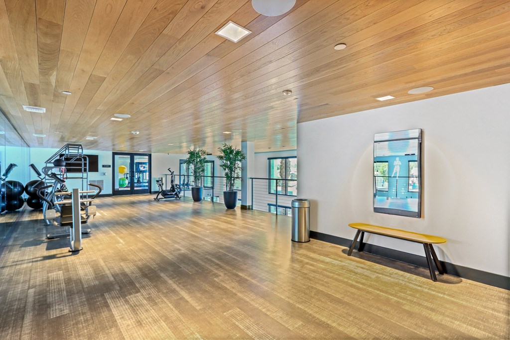 Large fitness room with a wood floor and white walls at Array La Mesa, La Mesa, 91942