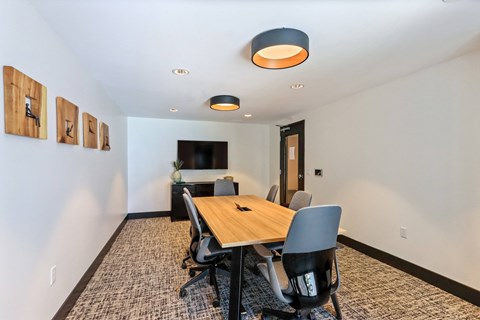 Meeting room with a wooden table and chairs and a flat screen tv on the wall at Array La Mesa, La Mesa California