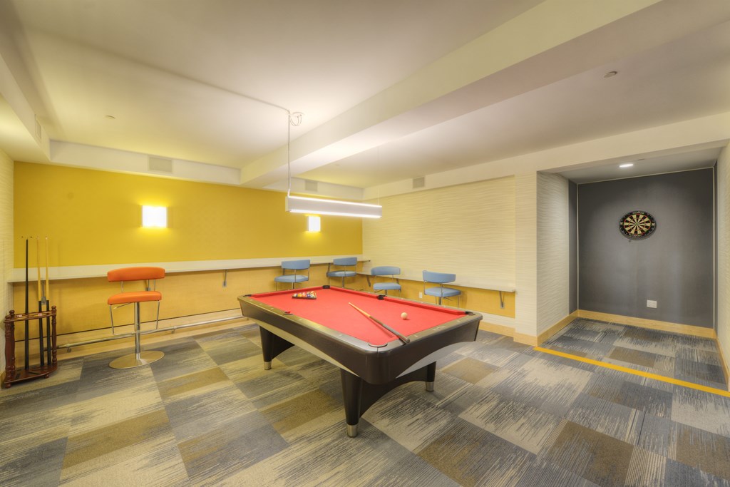 A pool table in a room with a yellow wall.