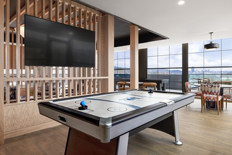 A pool table with a black cloth and white felt is in the center of the room.