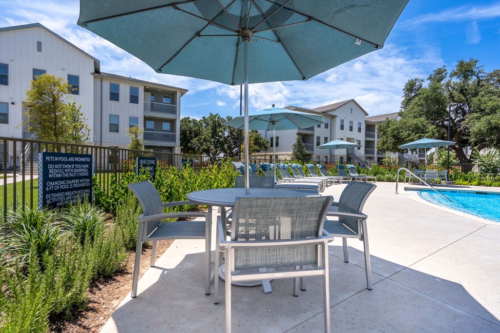 our apartments have a patio with tables and chairs and umbrellas