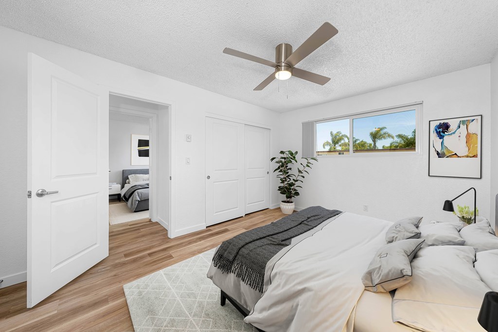 A bedroom with a large bed and a ceiling fan.