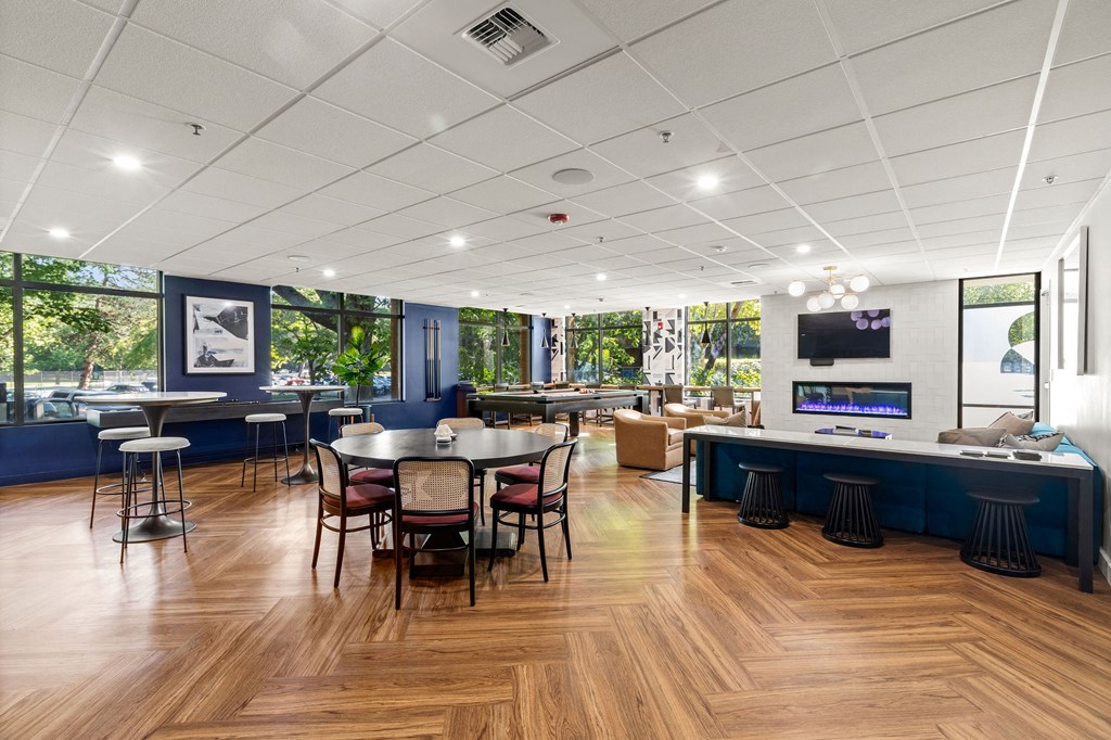 a dining room with tables and chairs and a bar with a television