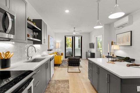 A modern kitchen with a large island and a dining area.