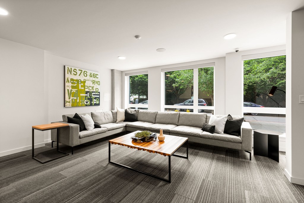 A modern living room with a grey sofa and a coffee table.