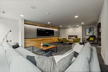 A modern living room with a grey sofa and a wooden bench.