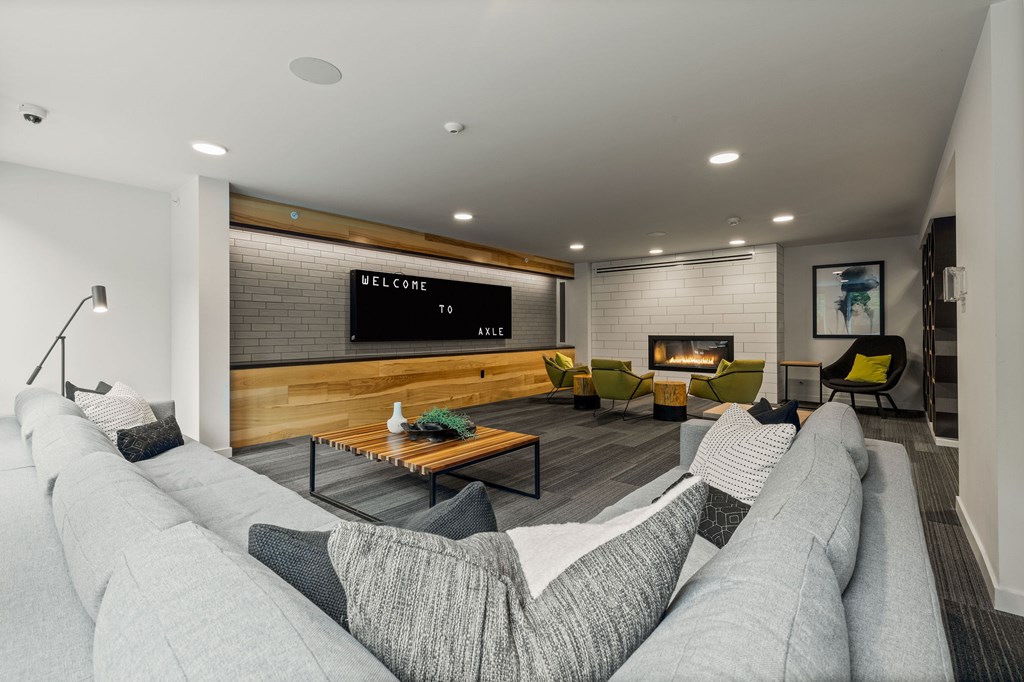 A modern living room with a grey sofa and a wooden bench.