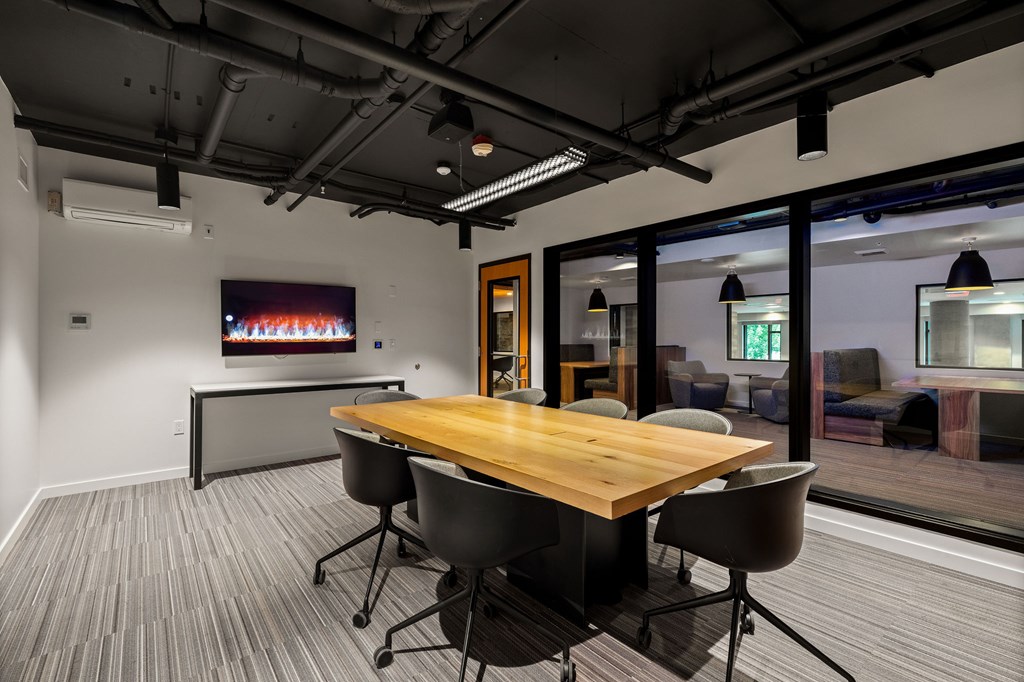 A conference room with a wooden table and chairs.
