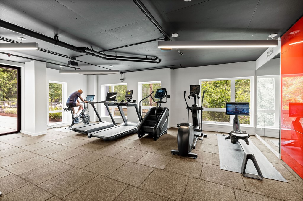 A man is working out on a stationary bike in a gym.