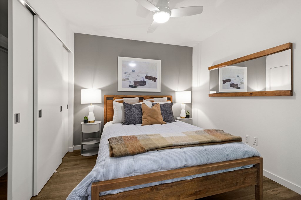 A bedroom with a bed, nightstands, and a ceiling fan.