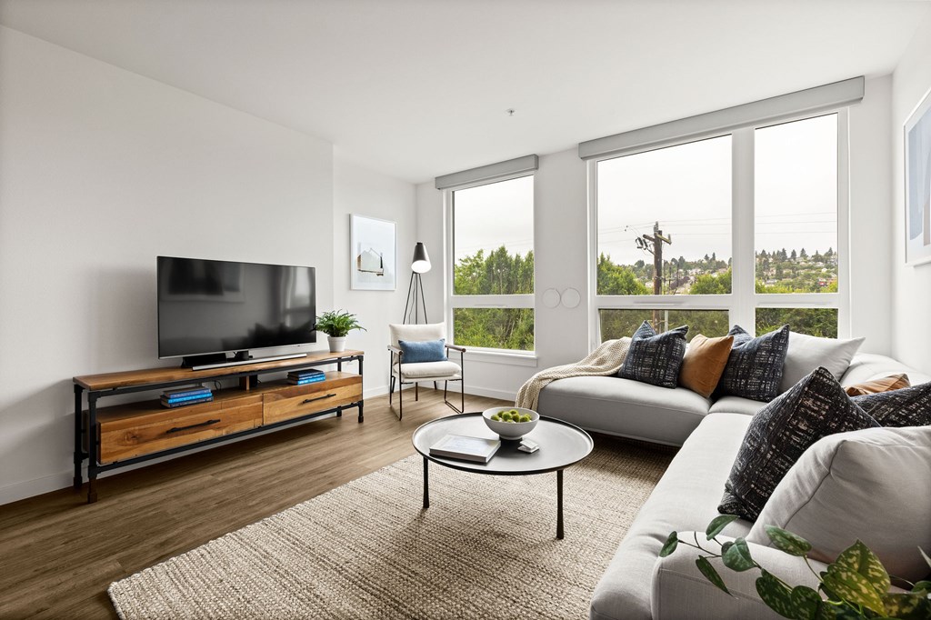 A modern living room with a flat screen TV and a large window.
