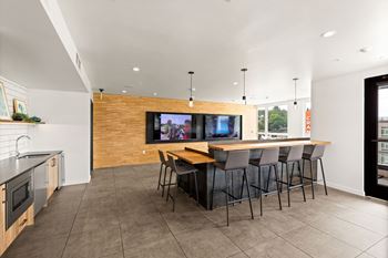 A modern kitchen with a bar area and a television.