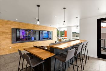 A modern dining room with a long wooden table and chairs.