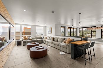 A modern living room with a long couch, a coffee table, and a dining table.