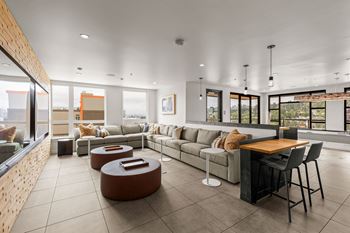 A modern living room with a long couch, a coffee table, and a dining table.