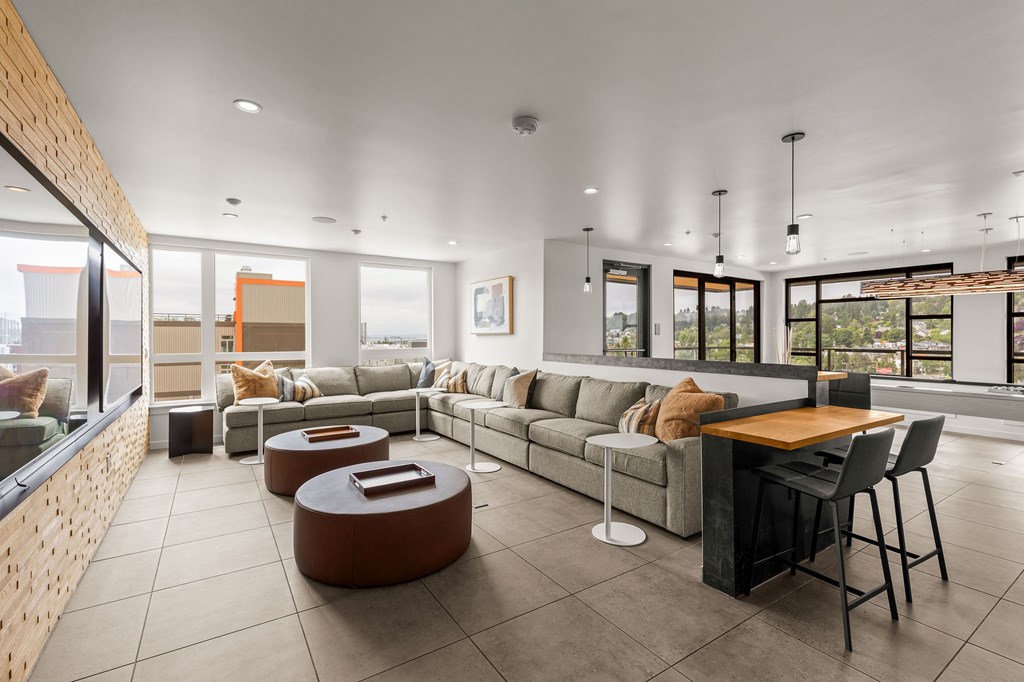 A modern living room with a long couch, a coffee table, and a dining table.