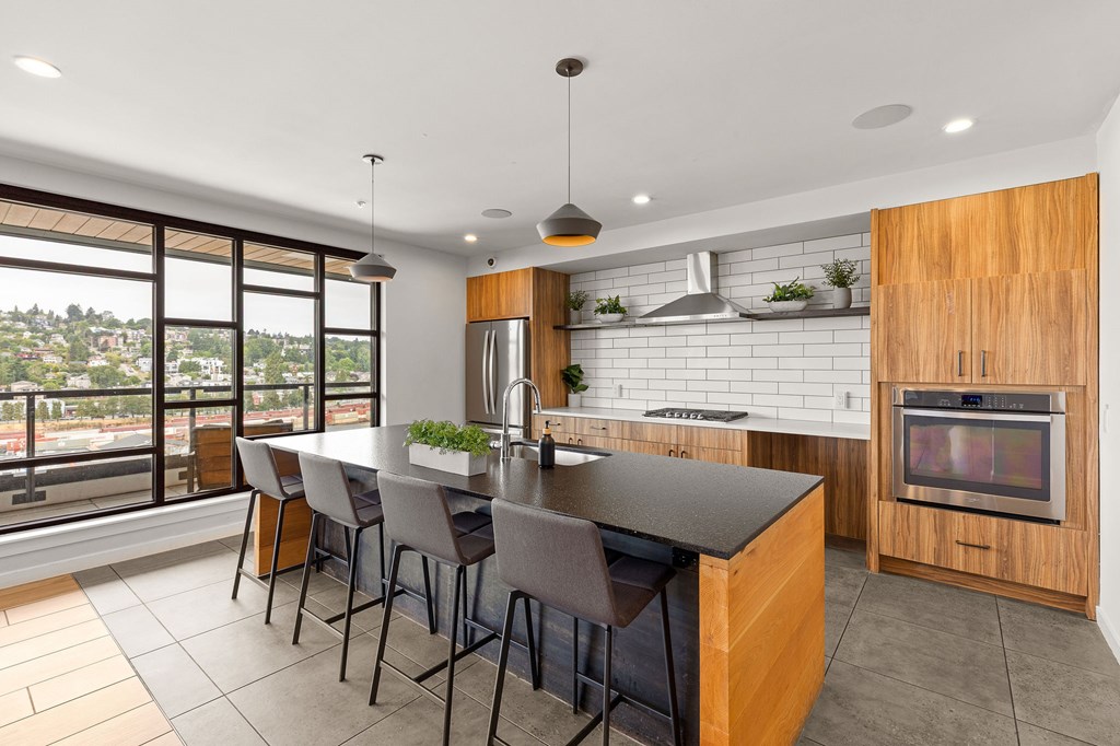 A modern kitchen with a large island and a view of the city.