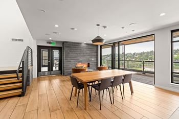 A modern dining room with a wooden table and chairs.
