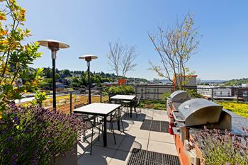 A patio with a table and chairs overlooking a city.