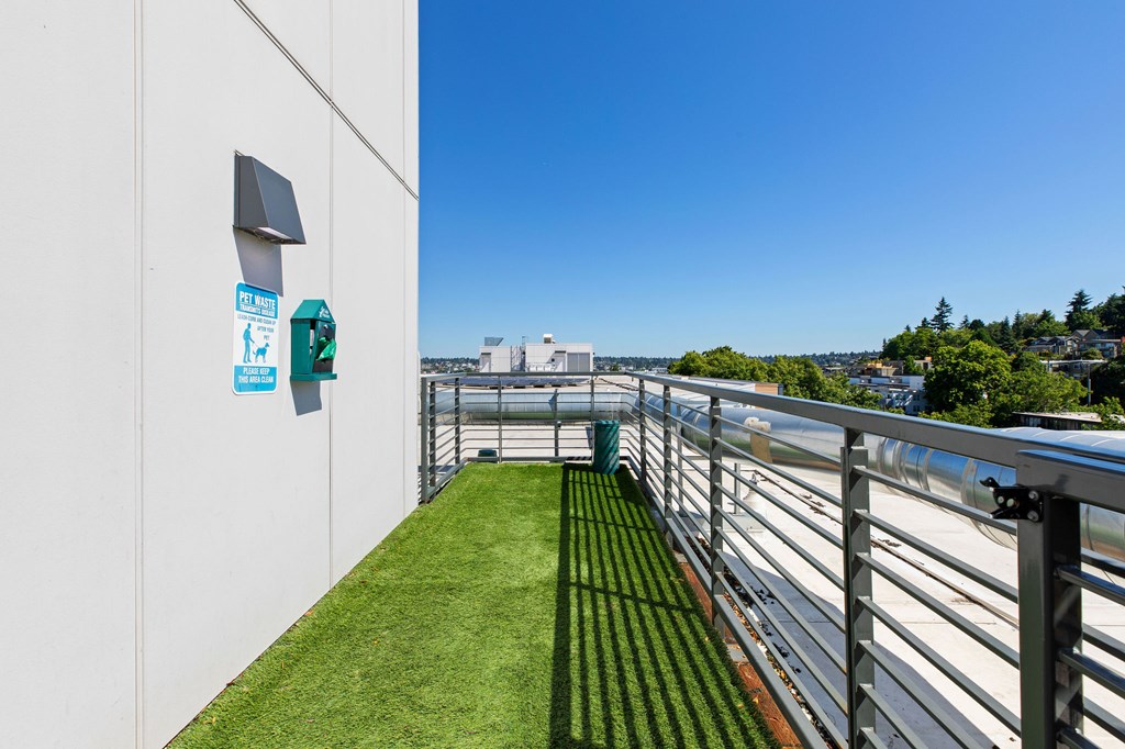 A white wall with a green sign and a small window.
