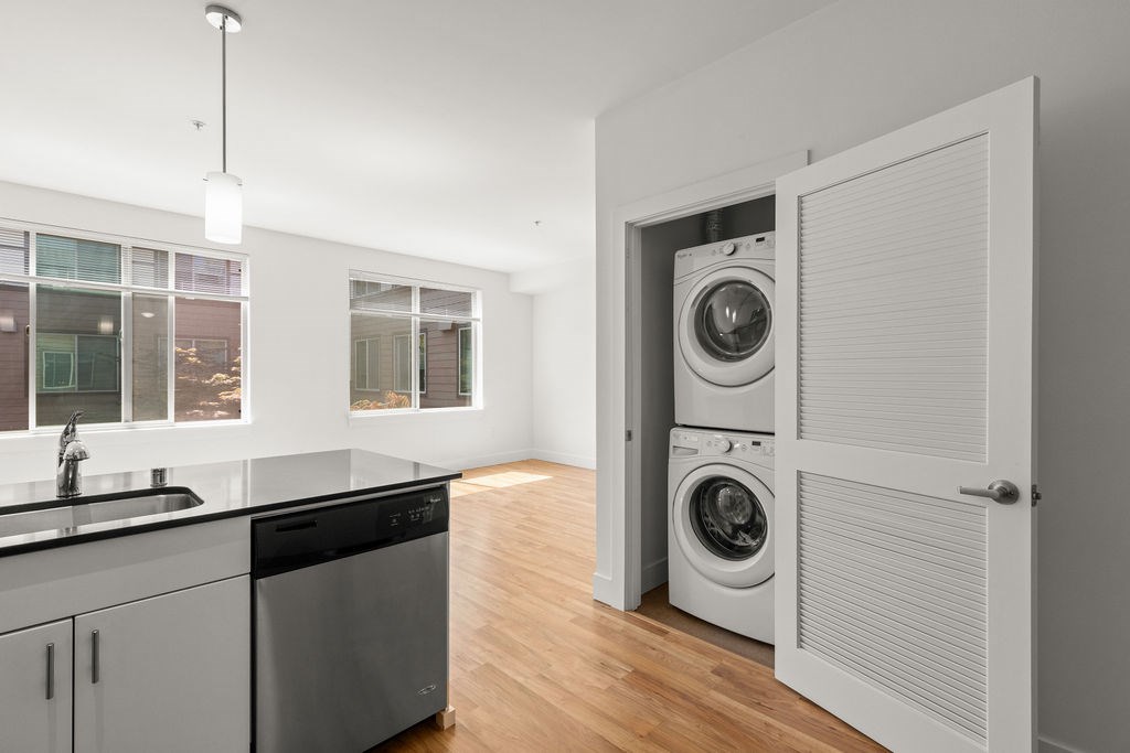 A modern laundry room with a washer and dryer stacked in a cabinet.