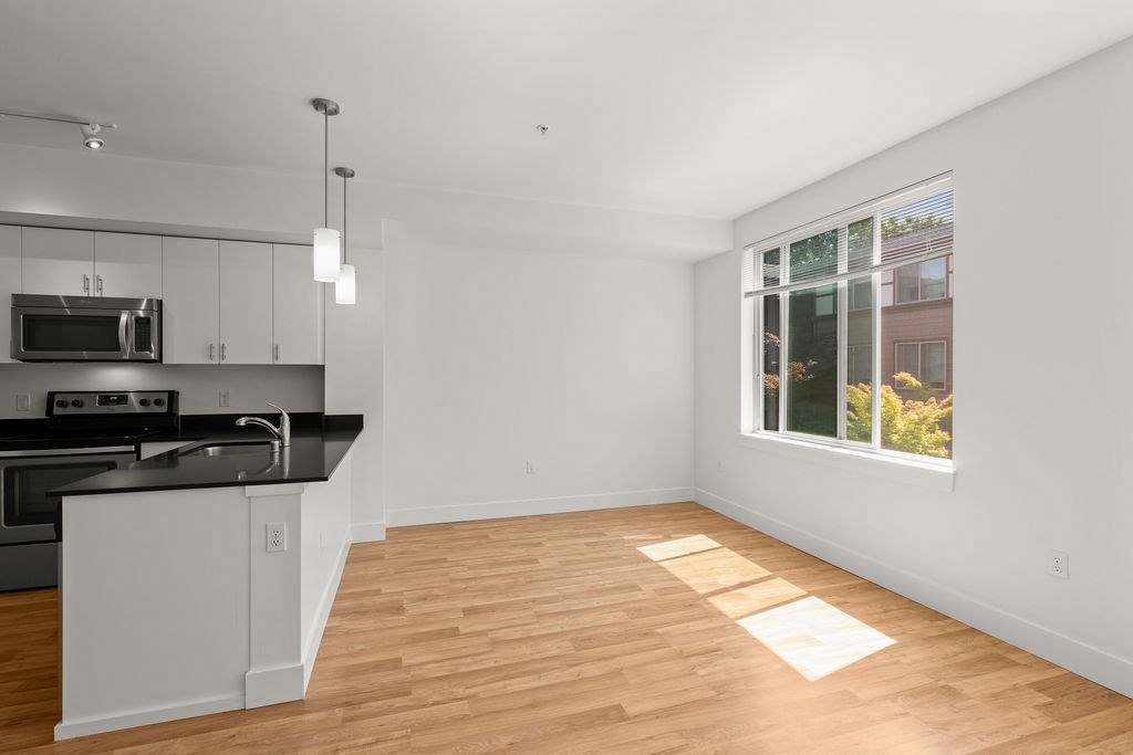 A kitchen with a black countertop and white cabinets.