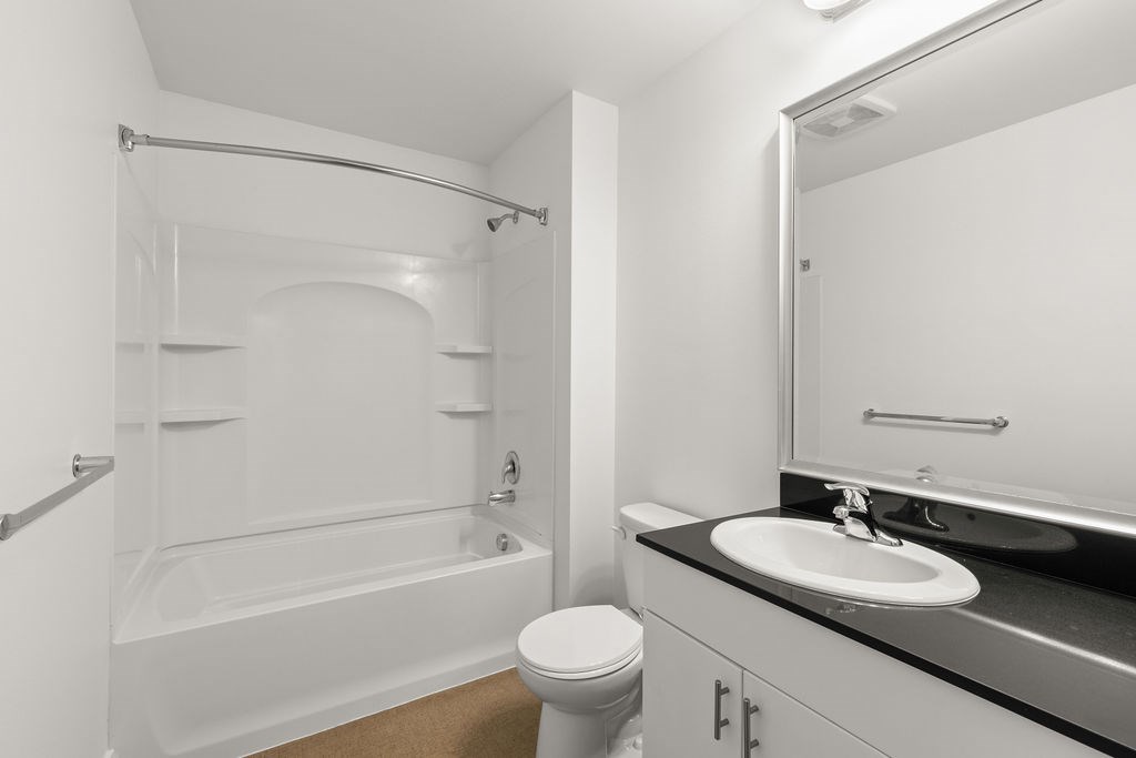 A white bathroom with a toilet, sink, and bathtub.