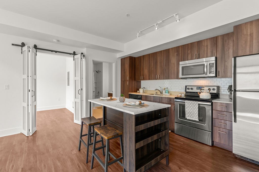 A kitchen with a white fridge, stove, and microwave.