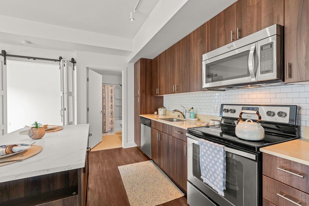 A modern kitchen with dark wood cabinets and a black stove top.