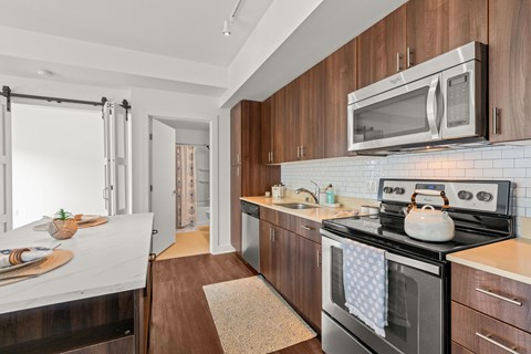 A modern kitchen with dark wood cabinets and a black stove top.