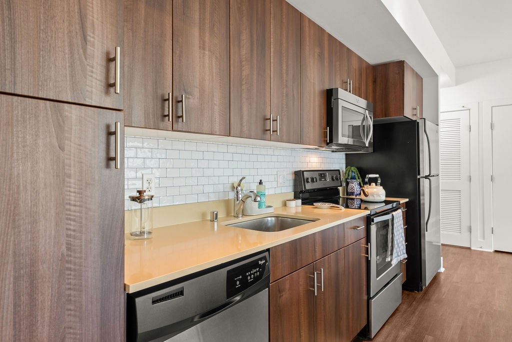 A kitchen with wooden cabinets and black appliances.